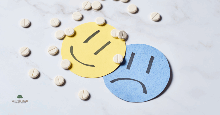 Yellow happy face and blue sad face surrounded by pills, symbolising anxiety, addiction, and dual diagnosis treatment at White Oak Recovery Center
