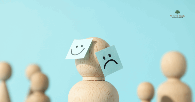 Wooden figure with happy and sad face notes attached, representing bipolar disorder and co-occurring addiction treatment at White Oak Recovery Center